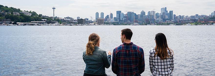 Three SPU students look out across Lake Union towards the Seattle skyline